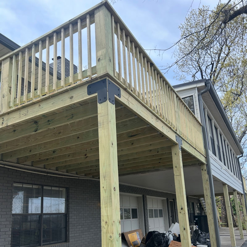 Raised custom wood deck connected to a Northwest Arkansas home.